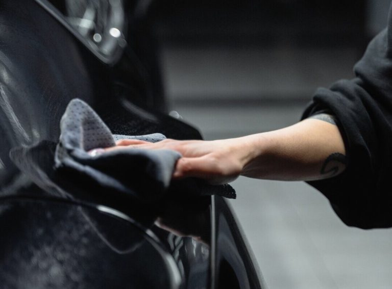 a person cleaning a car exterior